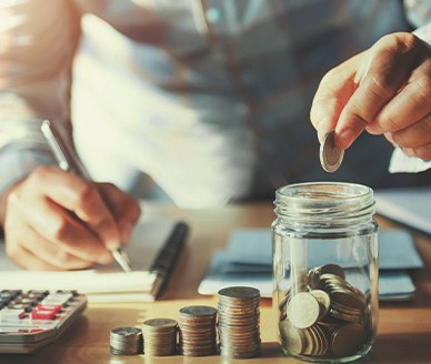 Someone putting coins into a jar