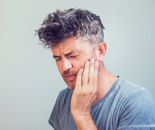 Grimacing man experiencing dental pain